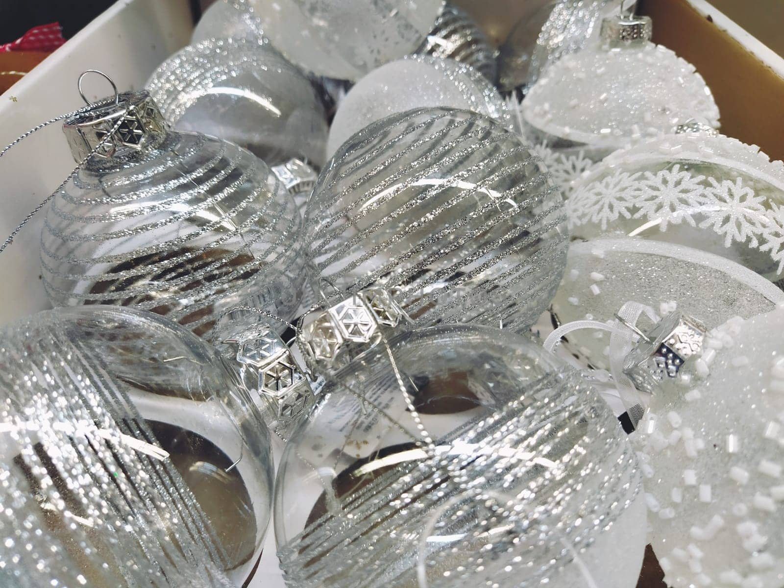 Large transparent beautiful Christmas balls in a box on a shelf in a store. Sale of Christmas New Year's toys and decorations before the holiday. Glass Christmas decorations