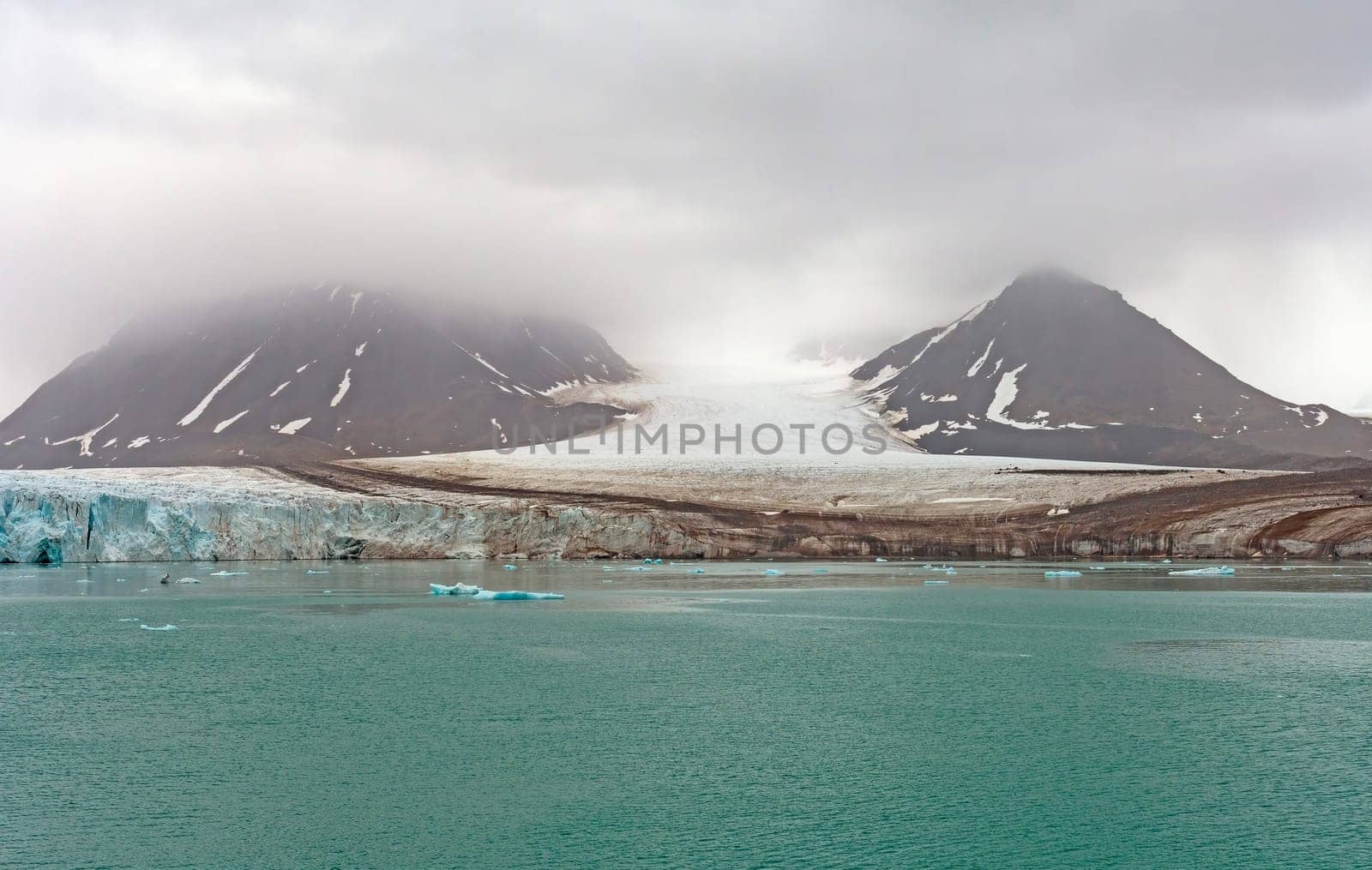 Tidal Glacier Coming Out of the Clouds at Lilliehookfjorden in the Svalbard Islands in Norway