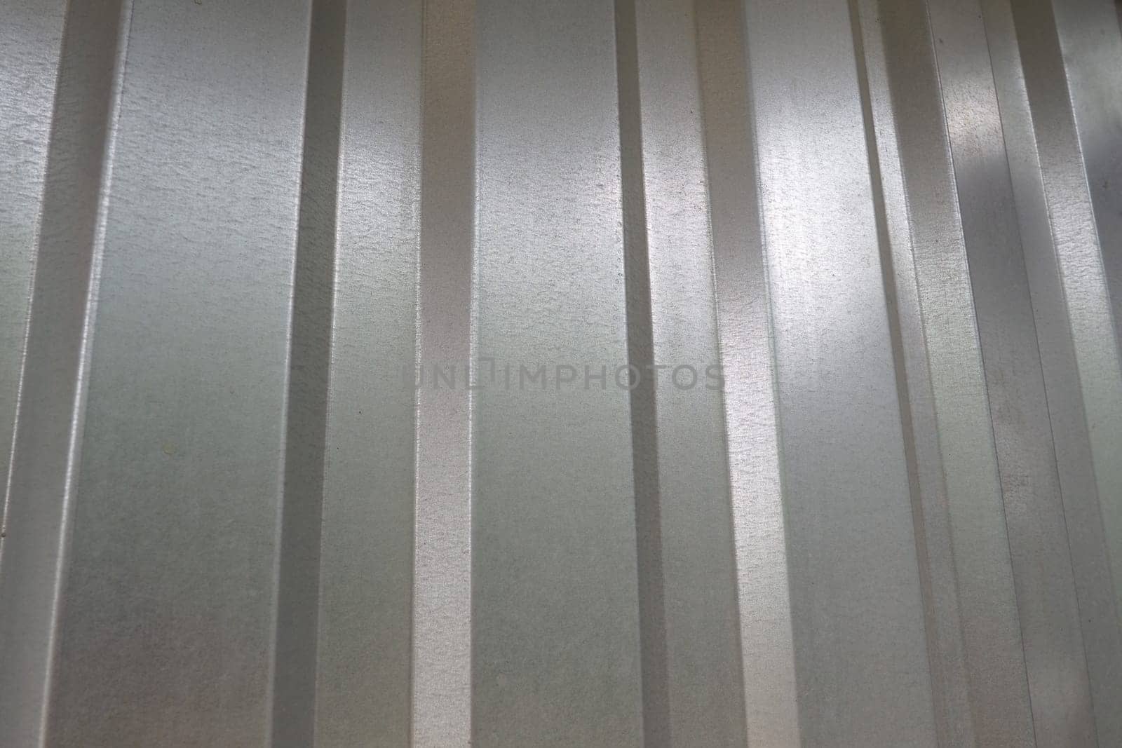 aluminum chrome metal profiled sheet with vertical stripes. metallic gray.