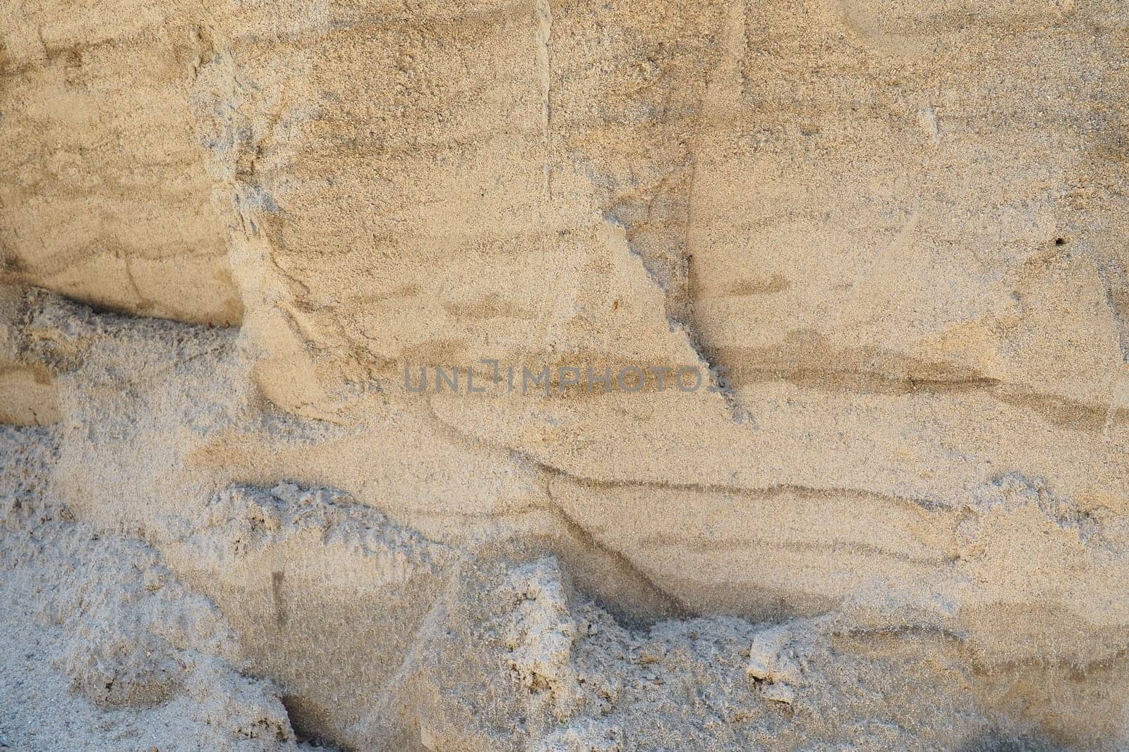 Sandstone is a fragmentary sedimentary rock, a homogeneous or layered aggregate of fragmentary grains and grains of sand bound by any mineral substance, cement. Quarry natural yellow sand wall