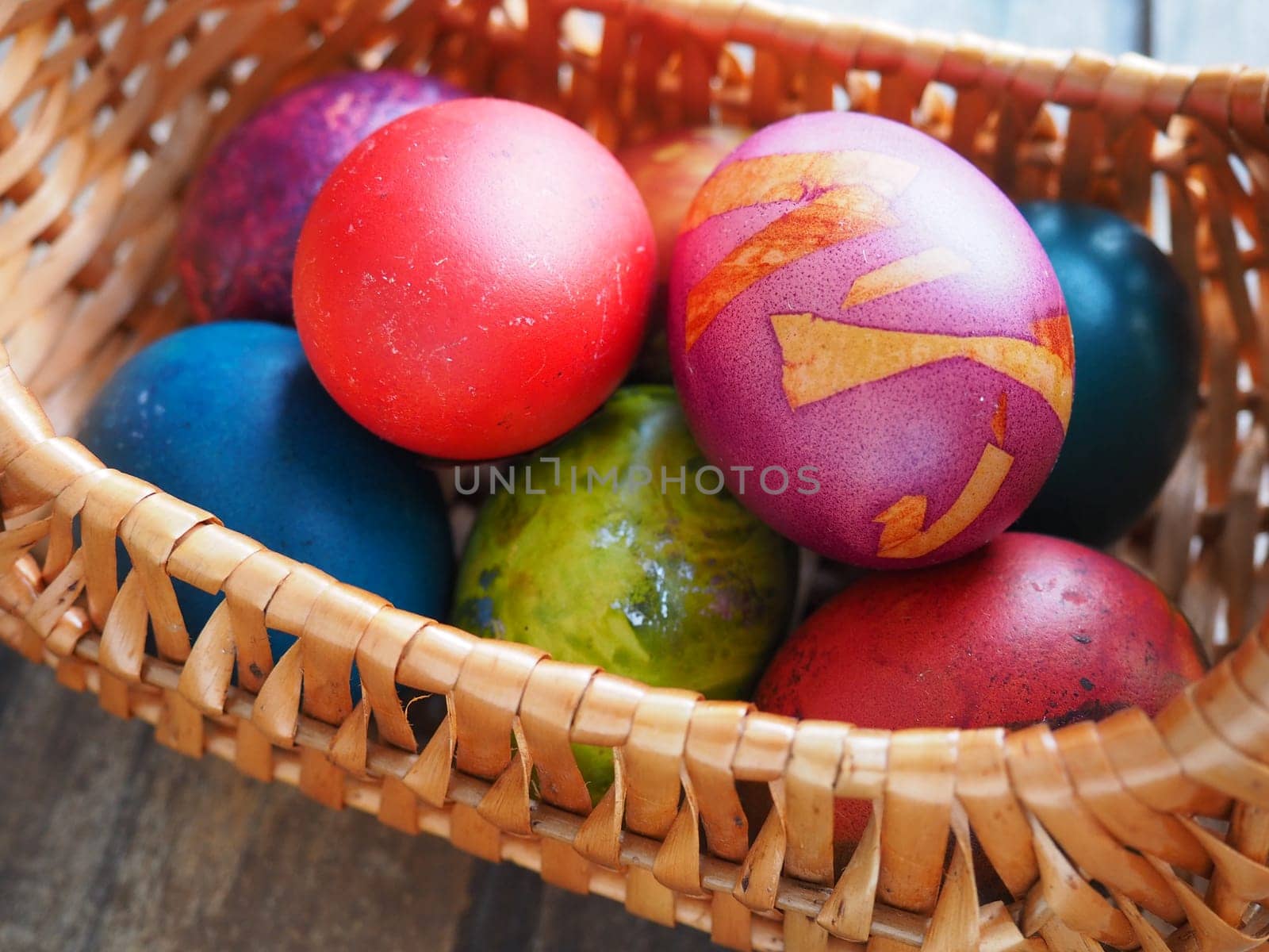 Happy Easter. Easter colored eggs in a wicker basket on a wooden table. Easter, the Resurrection of Christ, the Bright Resurrection of Christ, the most ancient and Christian holiday
