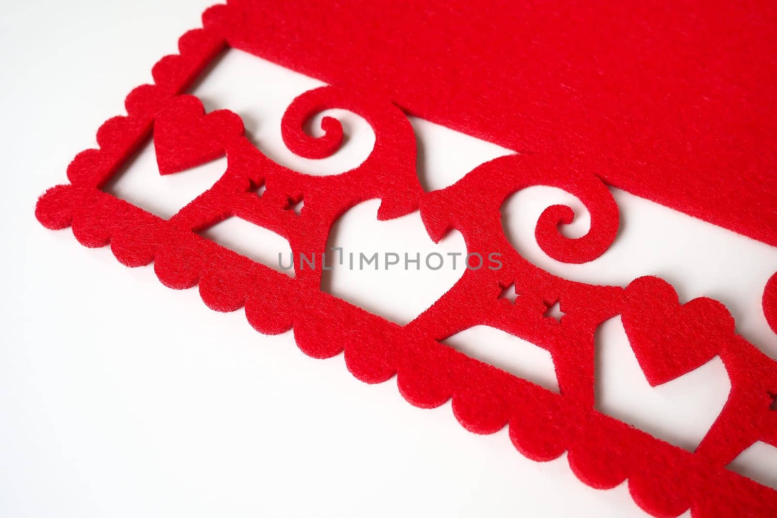 Background New Year's or for Valentine's Day. Kissing goats with stars and hearts are carved on red felt fabric. Merry Christmas and Happy New Year. Postcard, congratulation or invitation. Copy space