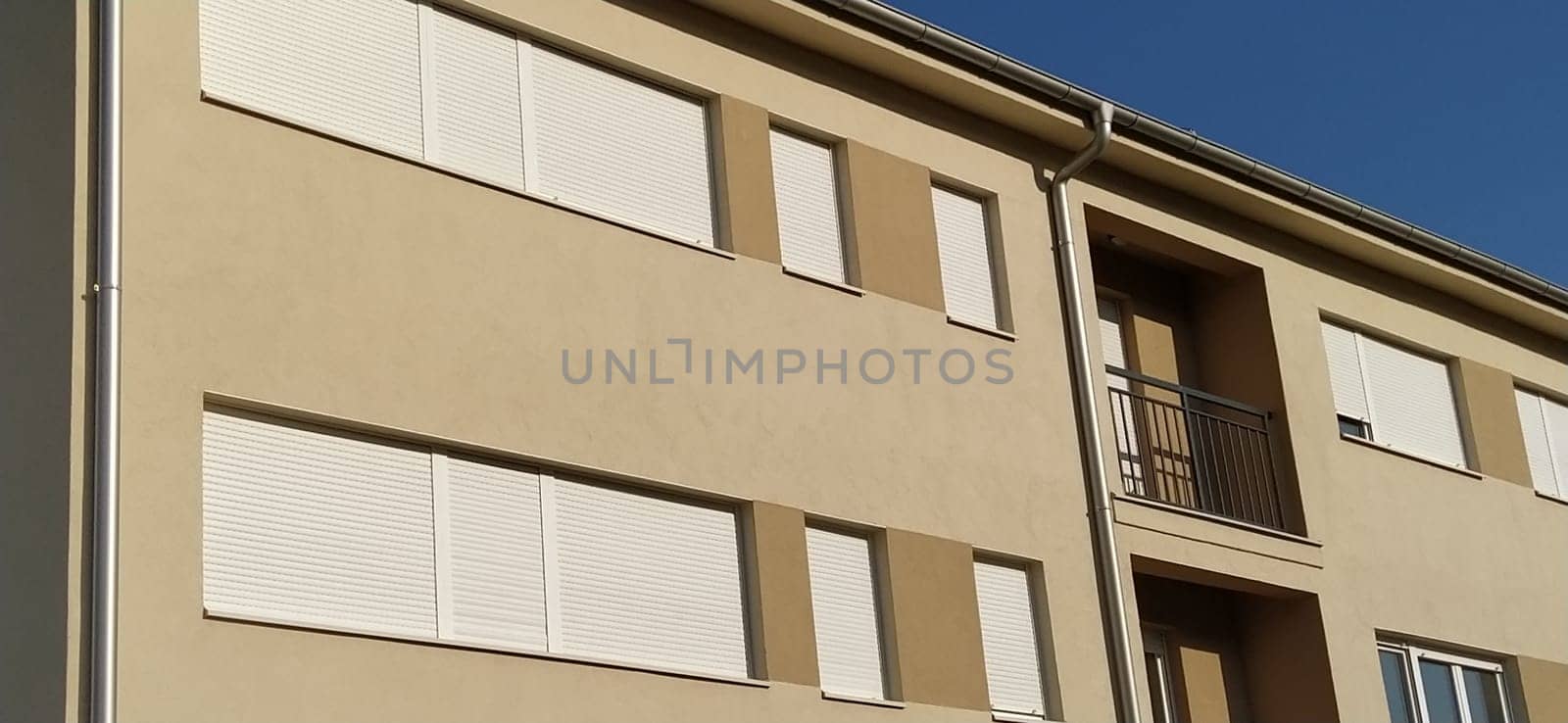 Facade of a new residential building. Modern buildings. Plaster beige wall.