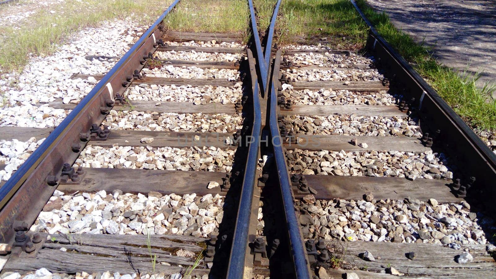 railways. Rails and sleepers on the ground near the station. Long way concept. Interlacing of tracks, railway arrows. Change of direction. Metal heavy rails.