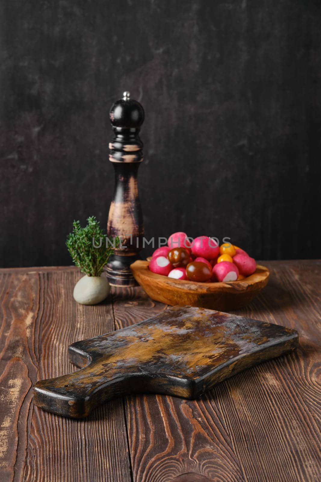 Rustic kitchen table with fresh vegetables and pepper mill blurred on background