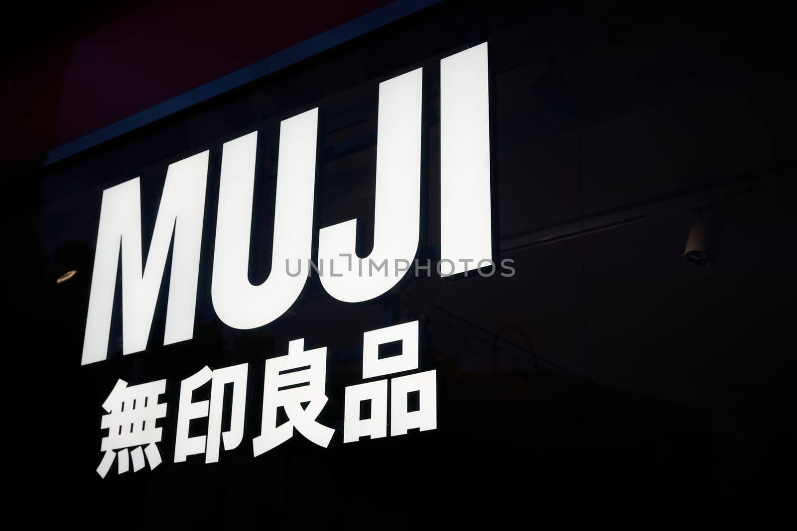 Illuminated sign of the Japanese unbranded lifestyle chain MUJI at a store in downtown Berlin. Renowned designers from all over the world work anonymously for MUJI