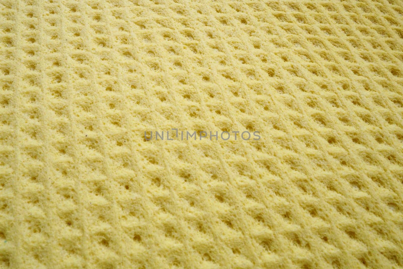 Sponge fibers sponge texture pattern surface close-up yellow background.