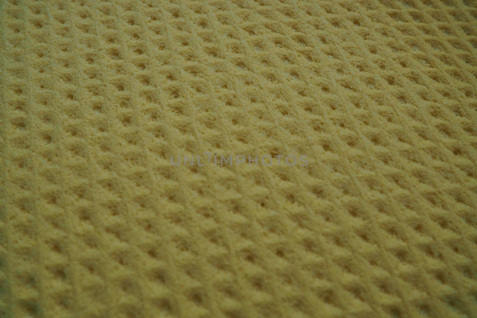 Sponge fibers sponge texture pattern surface close-up yellow brown background.