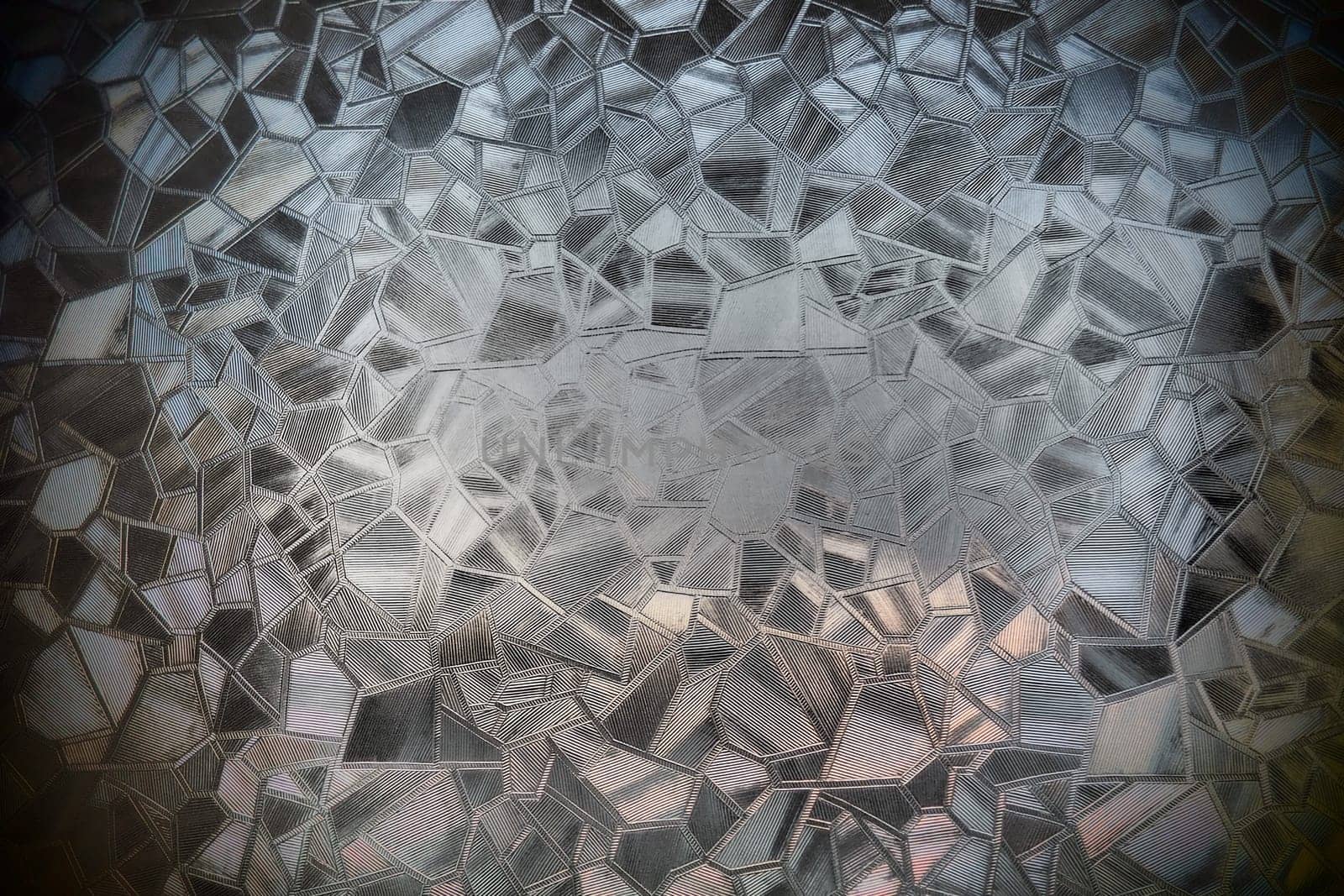 Fluted glass with backlight. Beautiful multicolored refraction of light. Abstract background. Self-adhesive film. Ribbed glass surface. Embossed glass background.