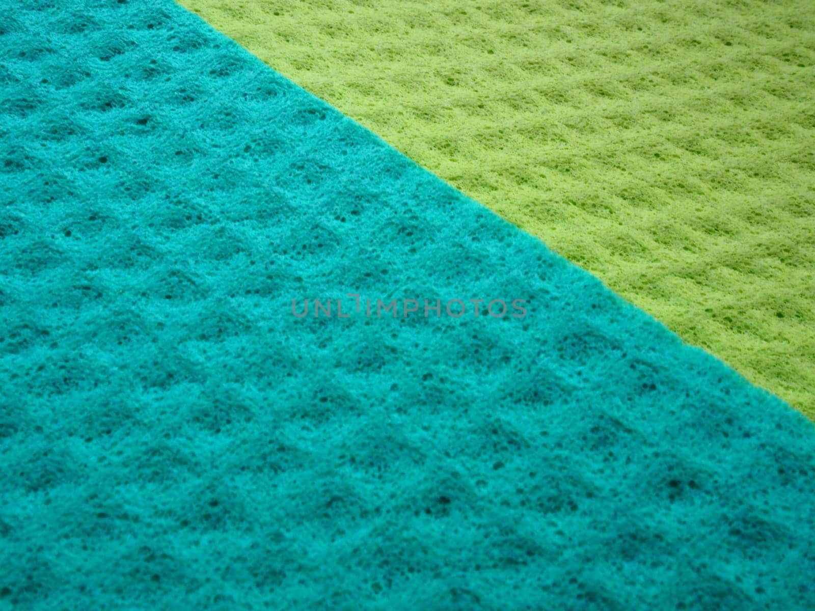 Sponge fibers sponge texture pattern surface close-up green yellow background.