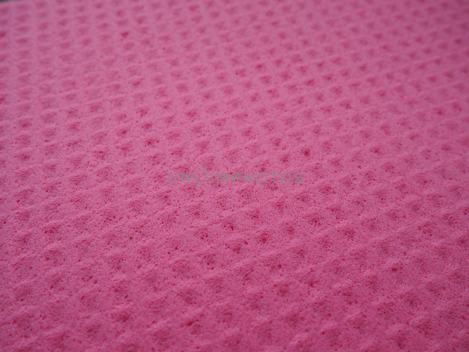 Sponge fibers sponge texture pattern surface close-up pink magenta background.