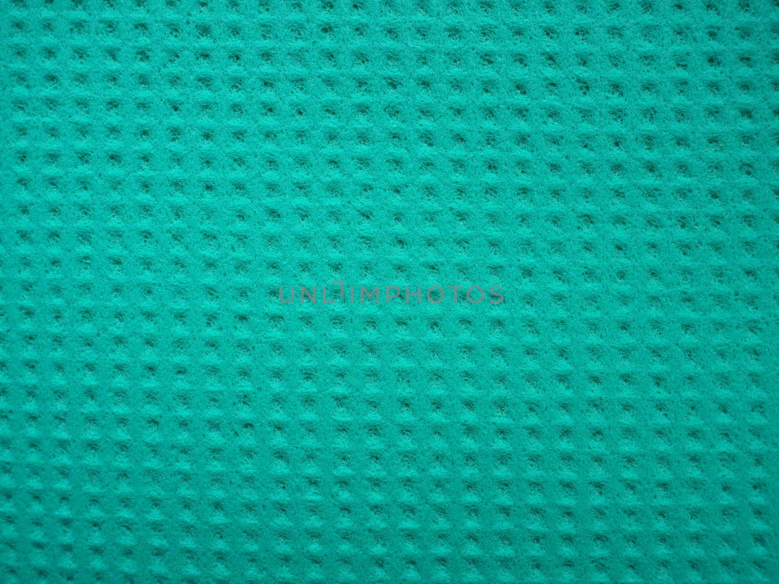 Sponge fibers sponge texture pattern surface close-up green background.