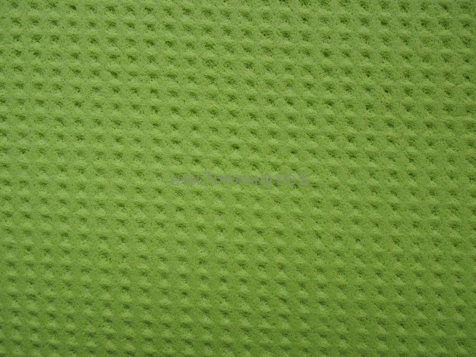 Sponge fibers sponge texture pattern surface close-up green yellow background.