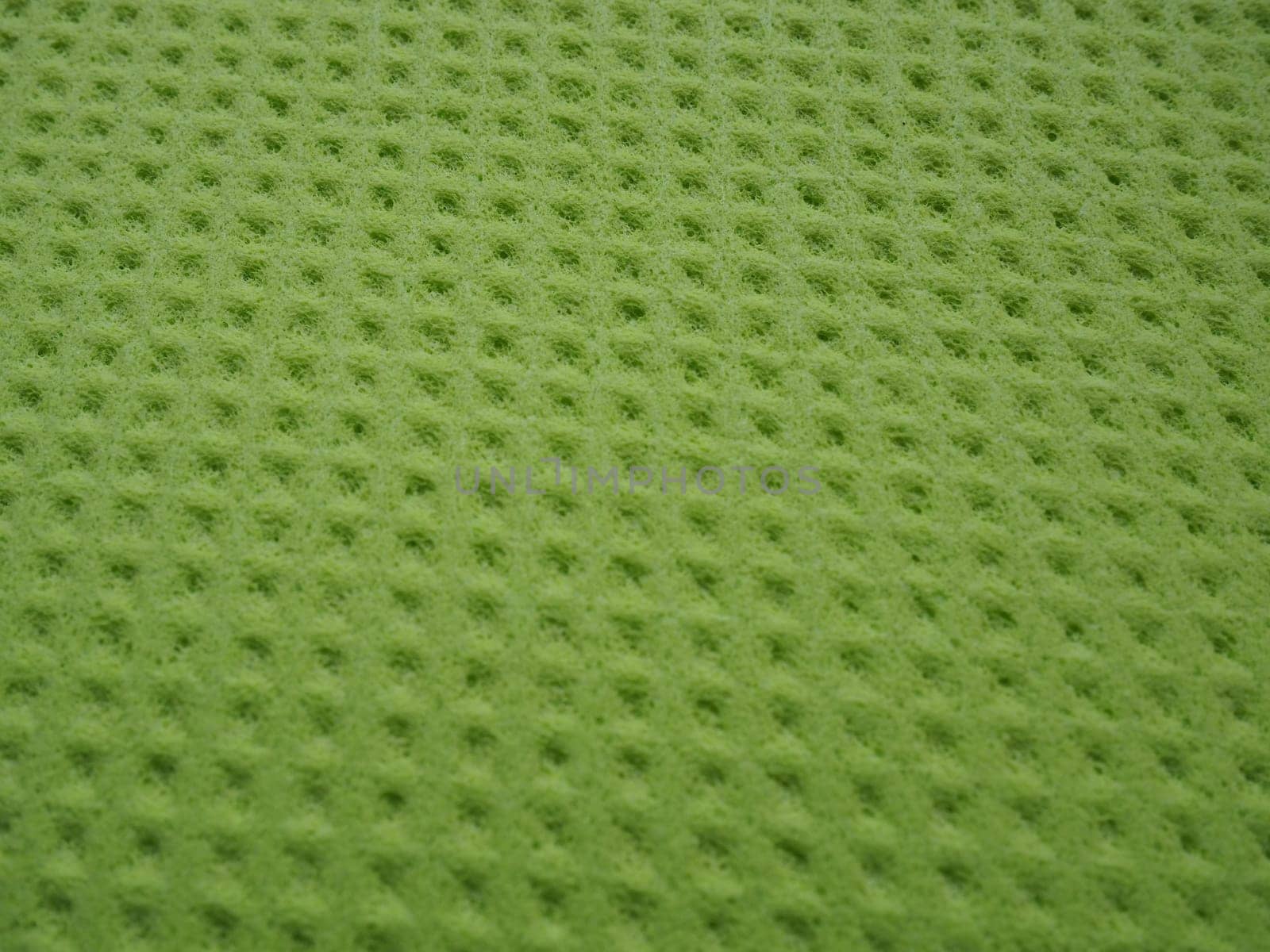 Sponge fibers sponge texture pattern surface close-up green yellow background.