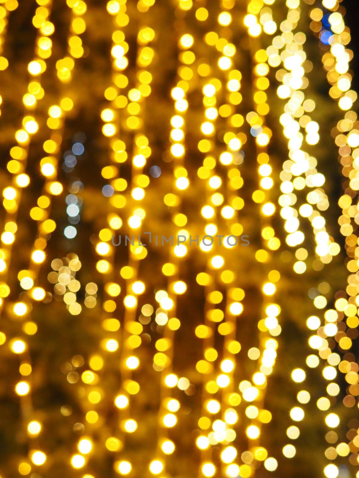 Festive garland. City night light blur bokeh, defocused background. Christmas bokeh. Beautiful lights against the black night sky. Street decoration for New Year and Christmas.