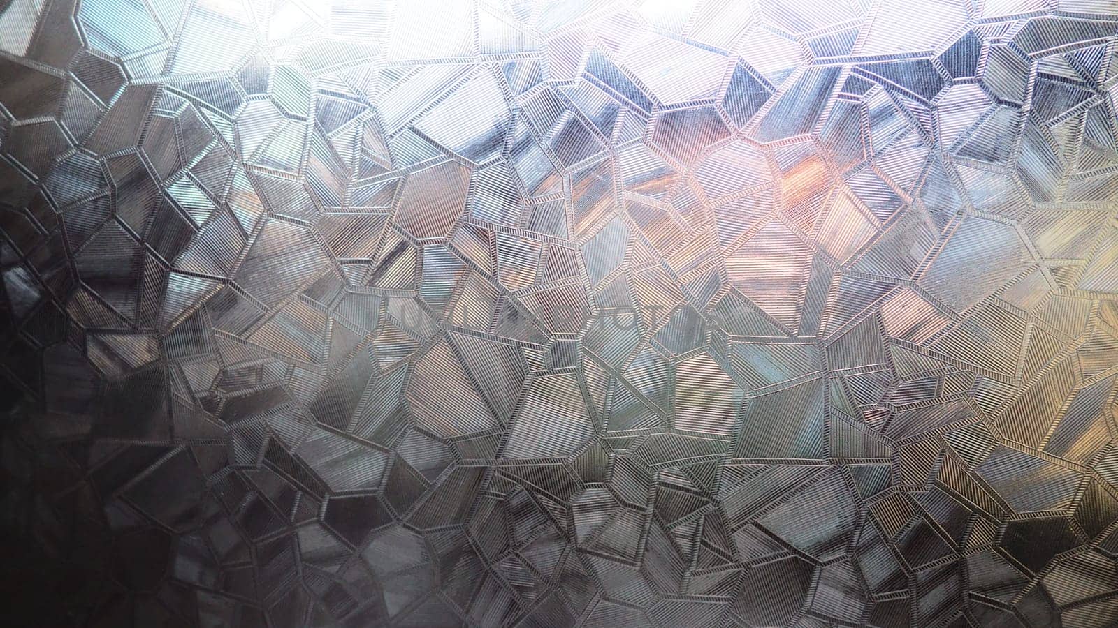 Fluted glass with backlight. Beautiful multicolored refraction of light. Abstract background. Self-adhesive film. Ribbed glass surface. Embossed glass background.