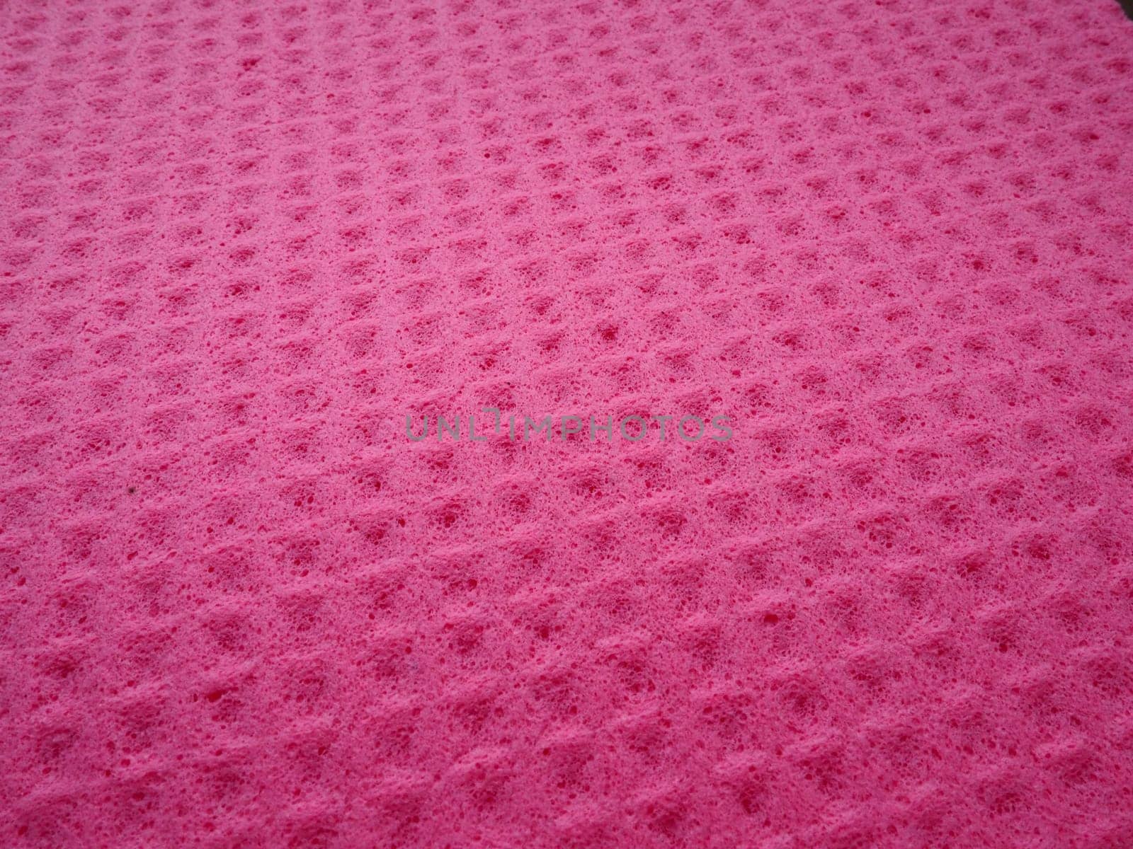 Sponge fibers sponge texture pattern surface close-up pink magenta background.