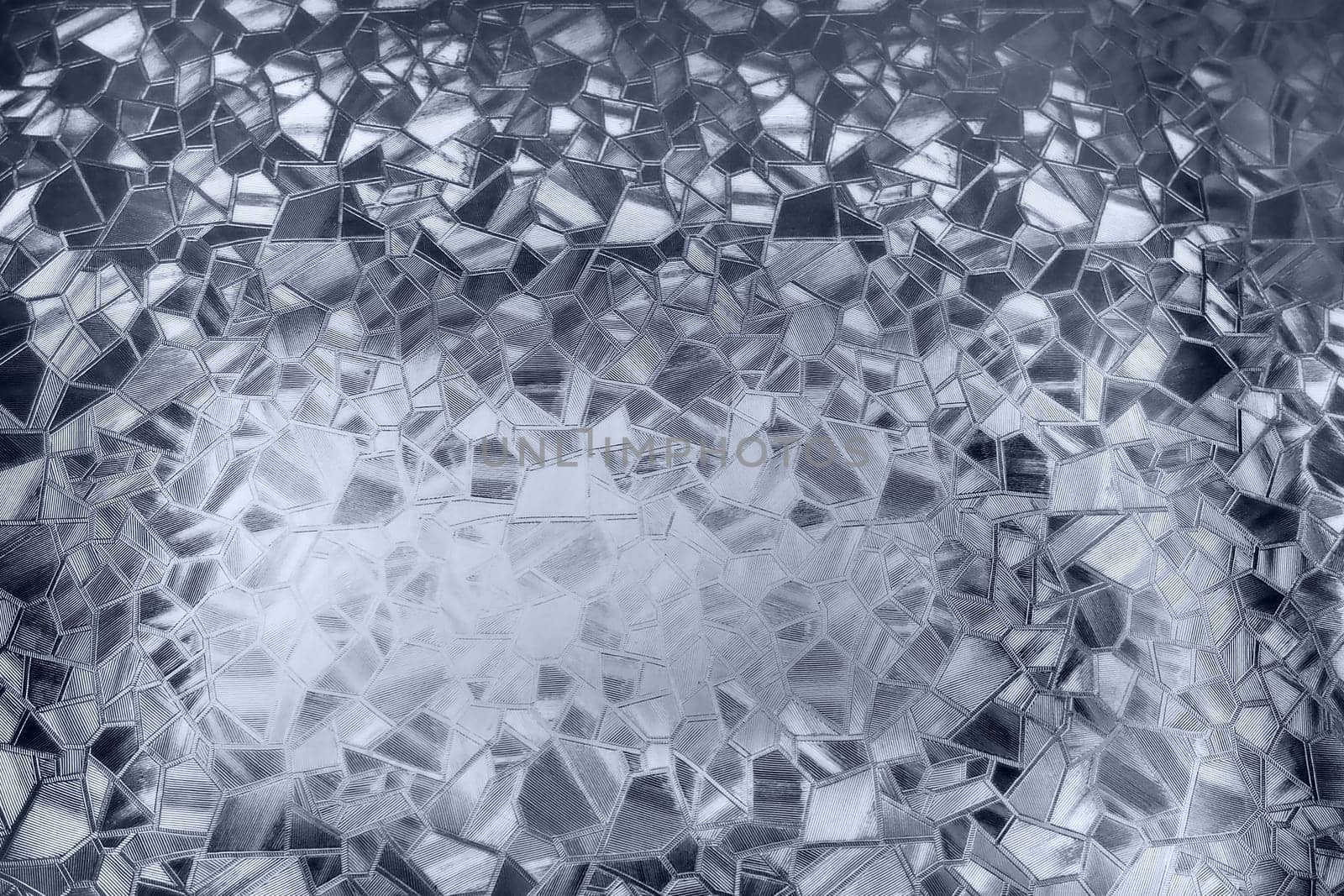 Embossed glass background. Corrugated glass monochrome. Refraction of light in a bumpy transparent surface under backlight. The play of white and gray highlights. Black areas. Abstract background