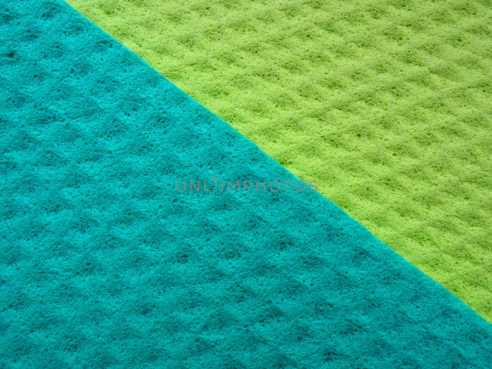 Sponge fibers sponge texture pattern surface close-up green yellow background.