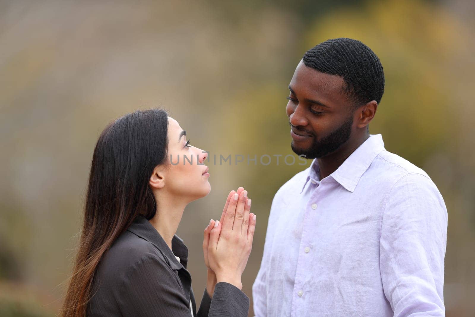 Woman begging forgive to a black man in a park