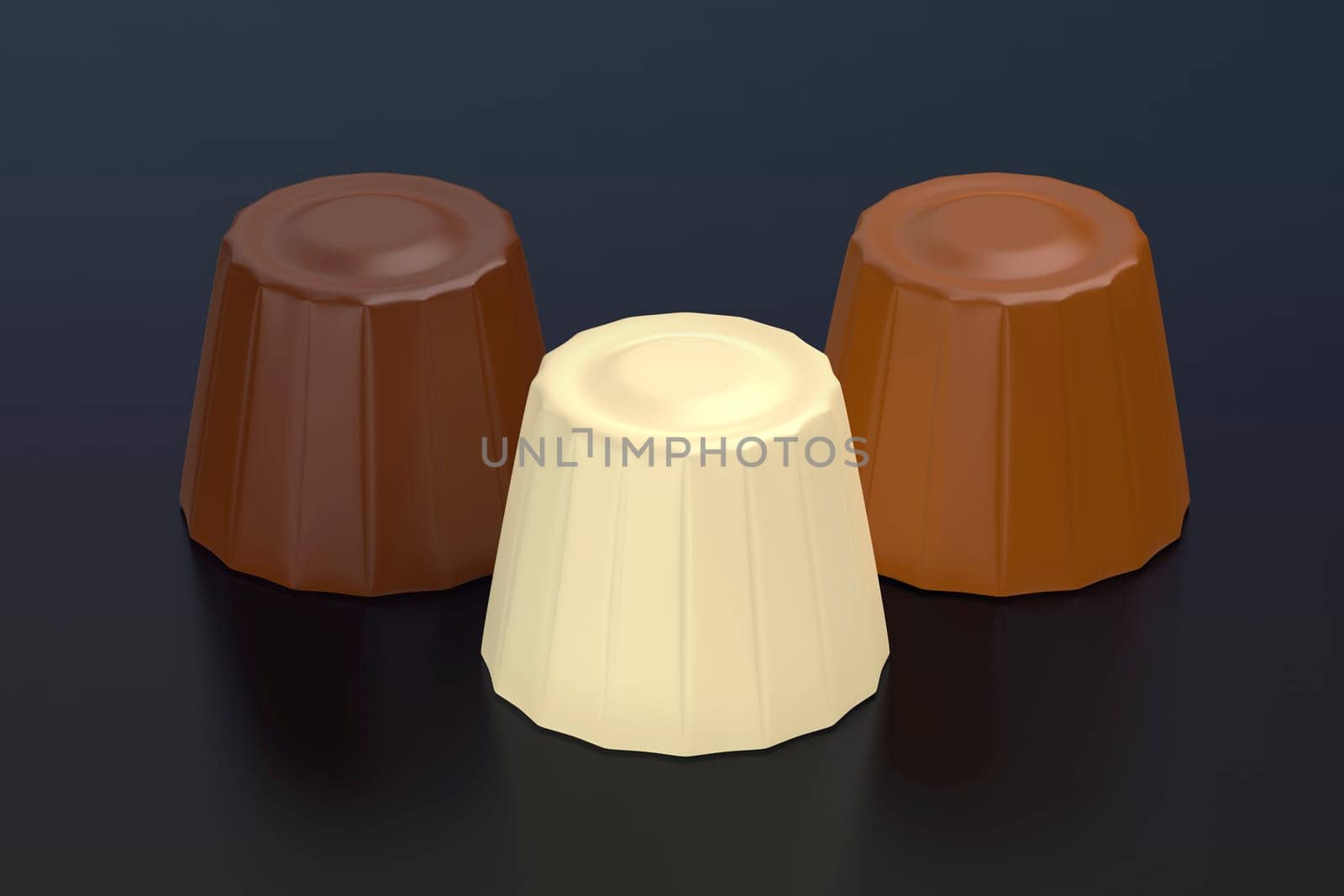 Milk, dark and white chocolate pralines on dark background