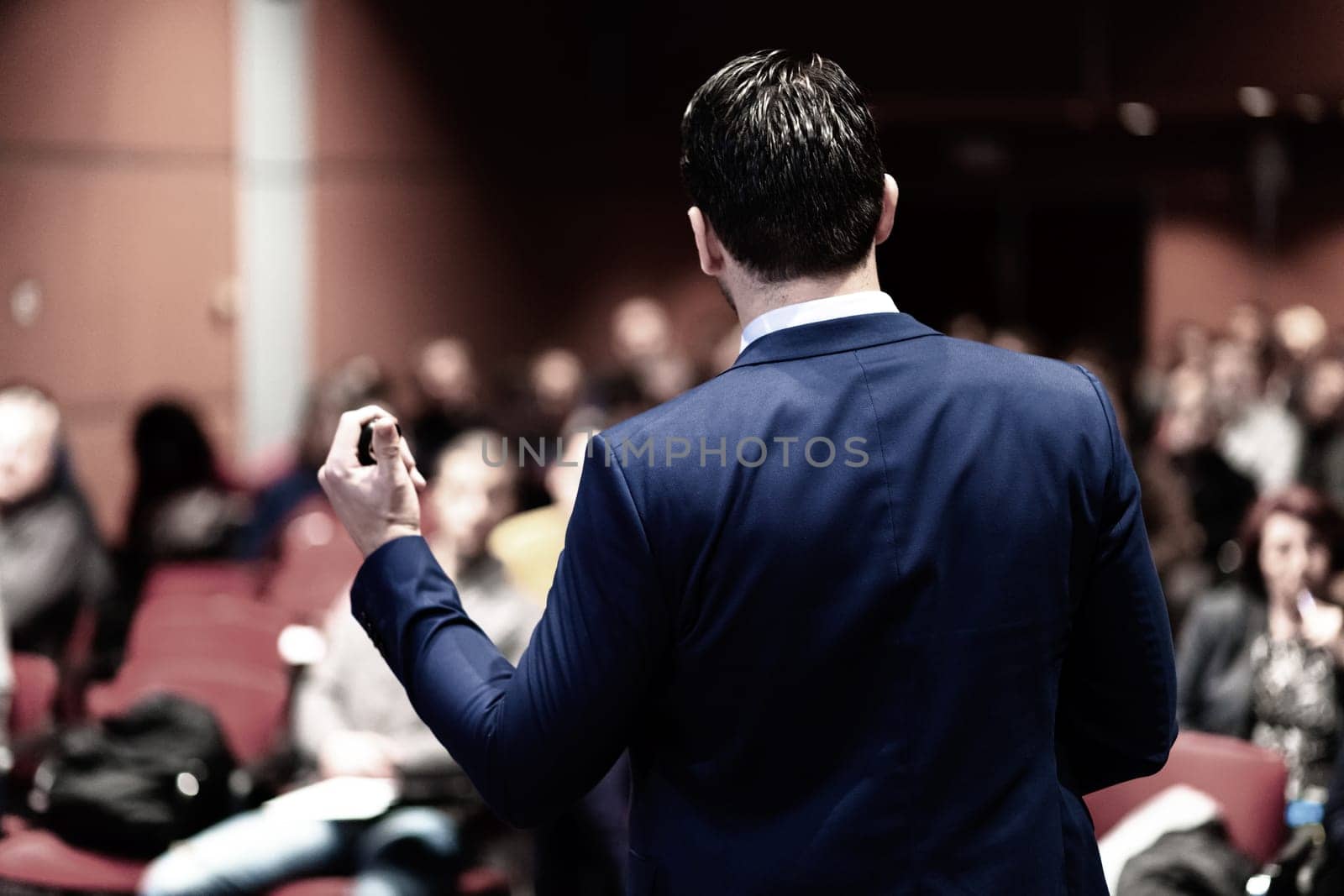 Speaker giving a talk on corporate Business Conference. Audience at the conference hall. Business and Entrepreneurship event.