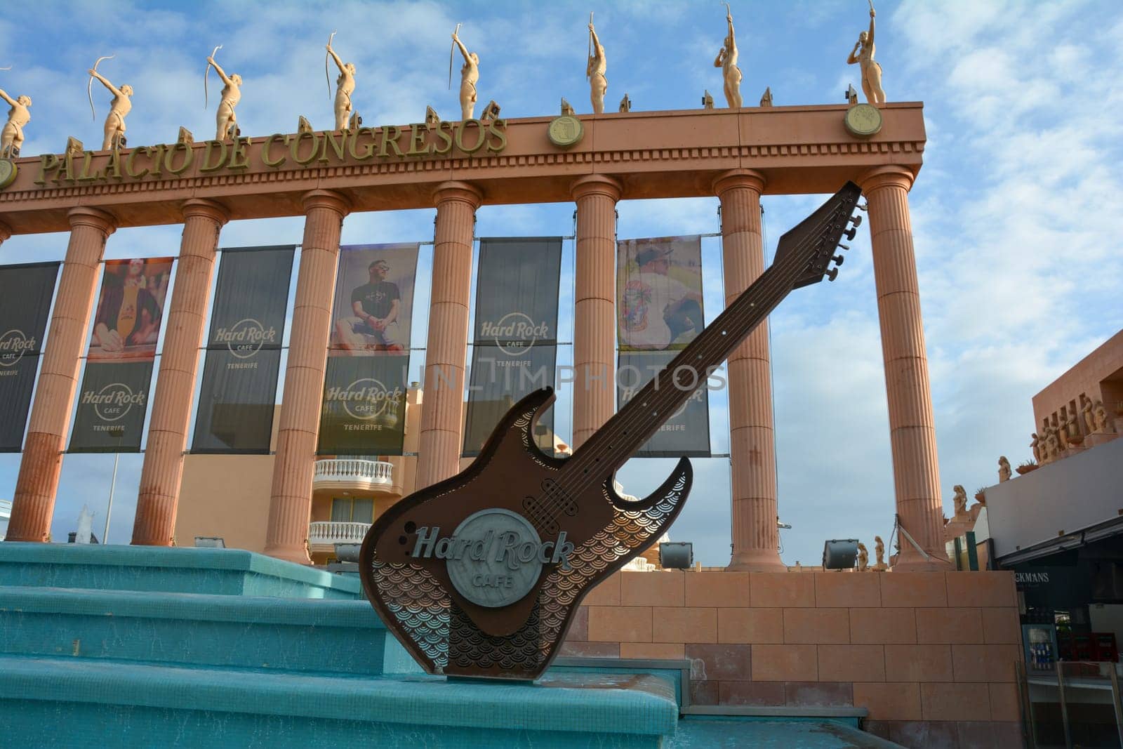 Hard Rock Cafe, Playa de la Americas, Tenerife, Spain August 12, 2022 - Building exterior with guitar , fountain and some archers figure and blue sky