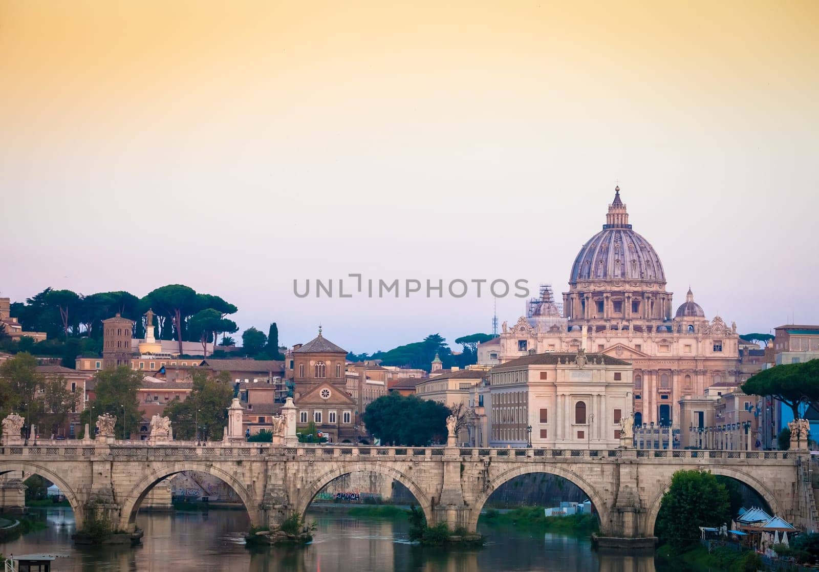 ROME, ITALY - JUNE 2020: sunset panorama on Tiber river bridge with Saint Peter Cathedral dome (Vatican City) in background - Rome, Italy