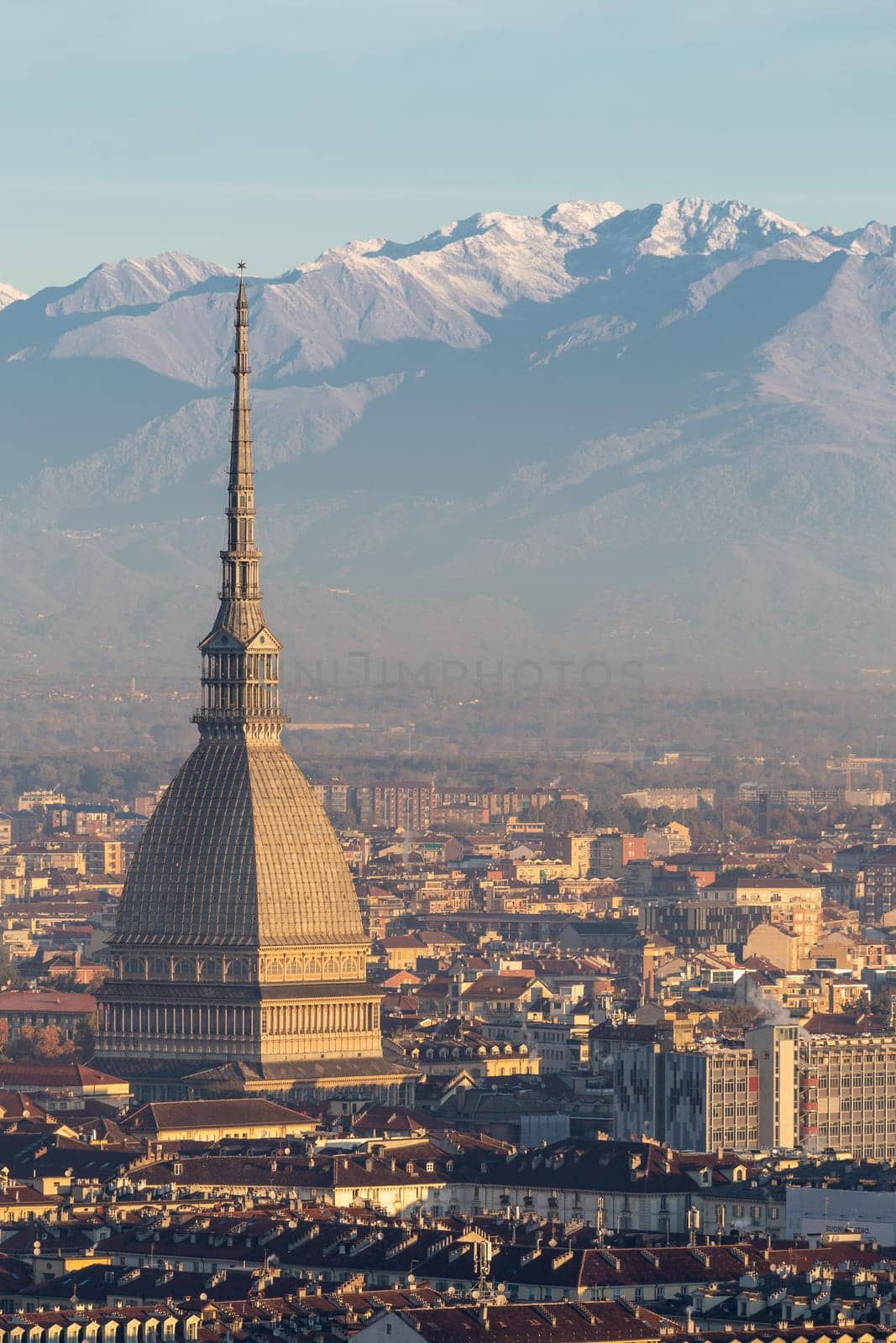 Turin, Italy - Circa November 2021: panorama with Alps and Mole Antonelliana,. Skyline of the symbol of Piedmont Region from Monte dei Cappuccini - Cappuccini's Hill. Sunrise light.