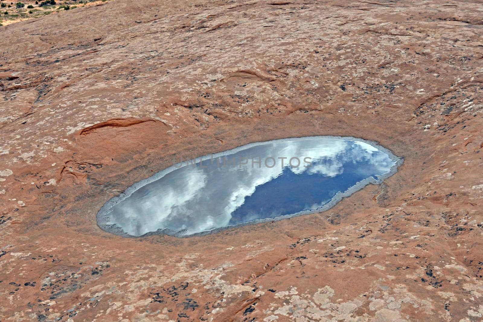 Clouds and Sky Reflected in a Desert Pool in Canyonlands National Park in Utah