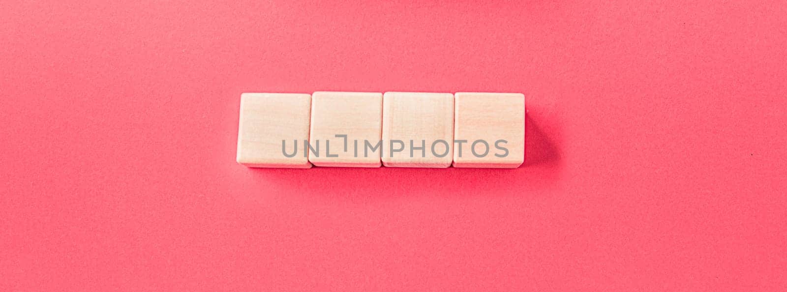 Wooden cubes isolated on pastel pink background with a place to insert text