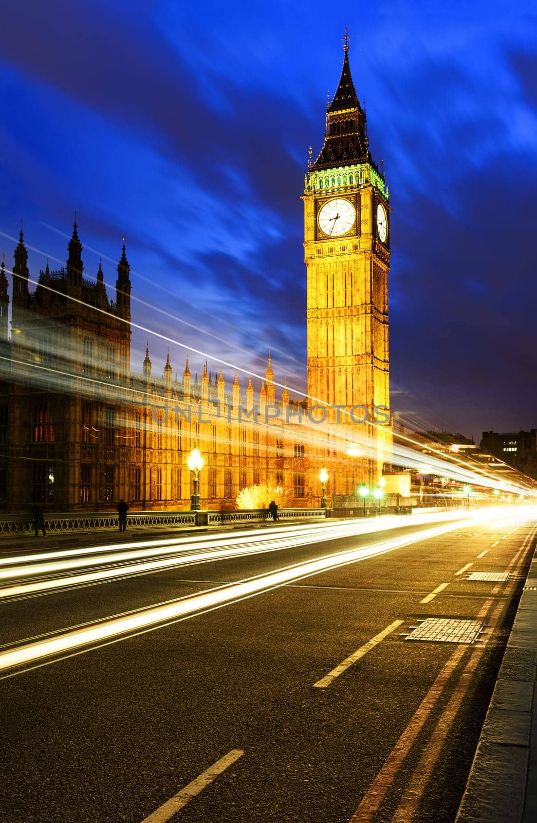 Big Ben, one of the most prominent symbols of both London and England, as shown at night along with the lights of the cars passing