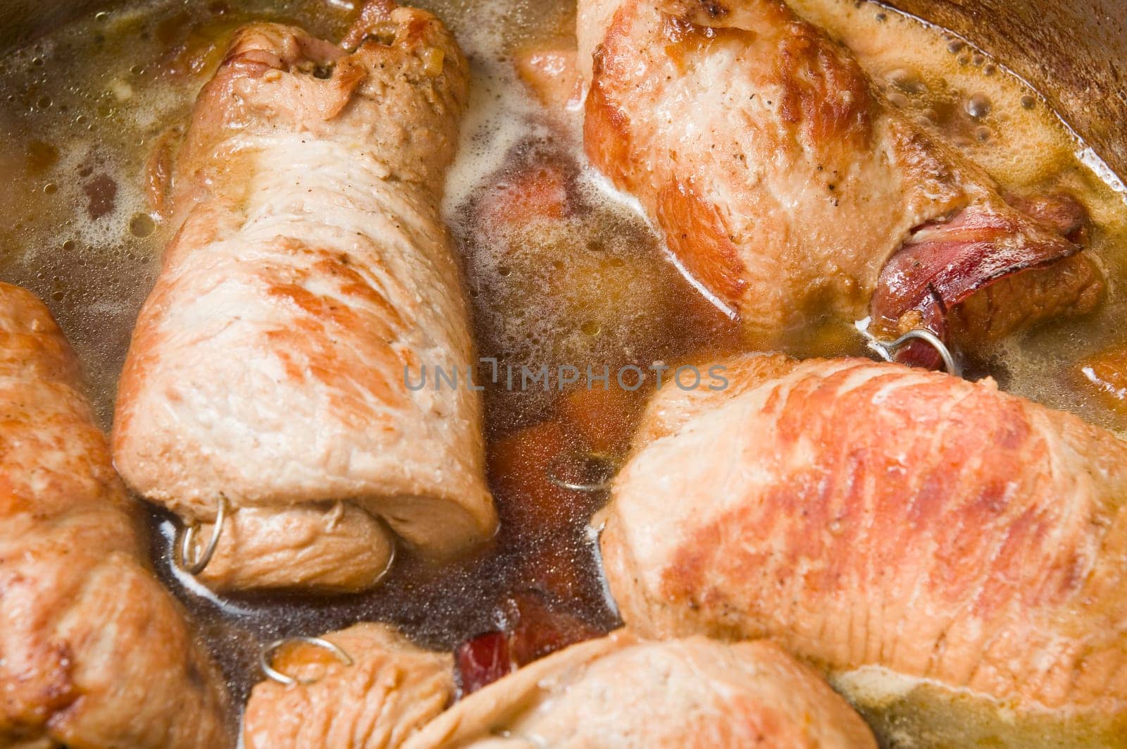 Close-up in a cooking pot of simmering poultry roulades