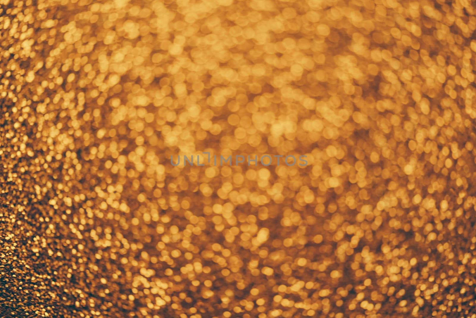 Golden glitter textured background for christmas and new year celebration party. Gold dust sparkling texture top view. Luxury and glamour bronze and brass pattern backdrop.