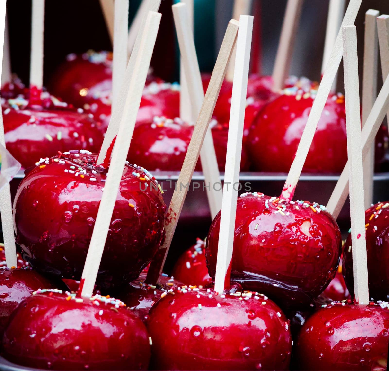 Red candy apple on holiday fair market closeup. Traditional sweet glazed apples for halloween treats.