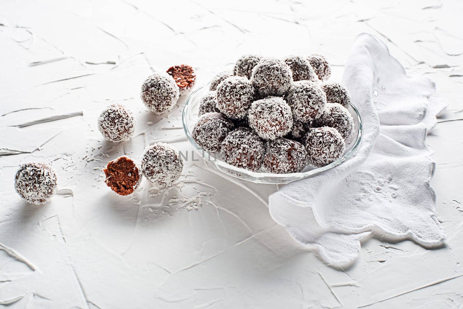 Delicious Coconut-Chocolate balls covered with grated coconut. Soft, delicious and fudgy coconut balls with rum, biscuit and chocolate
