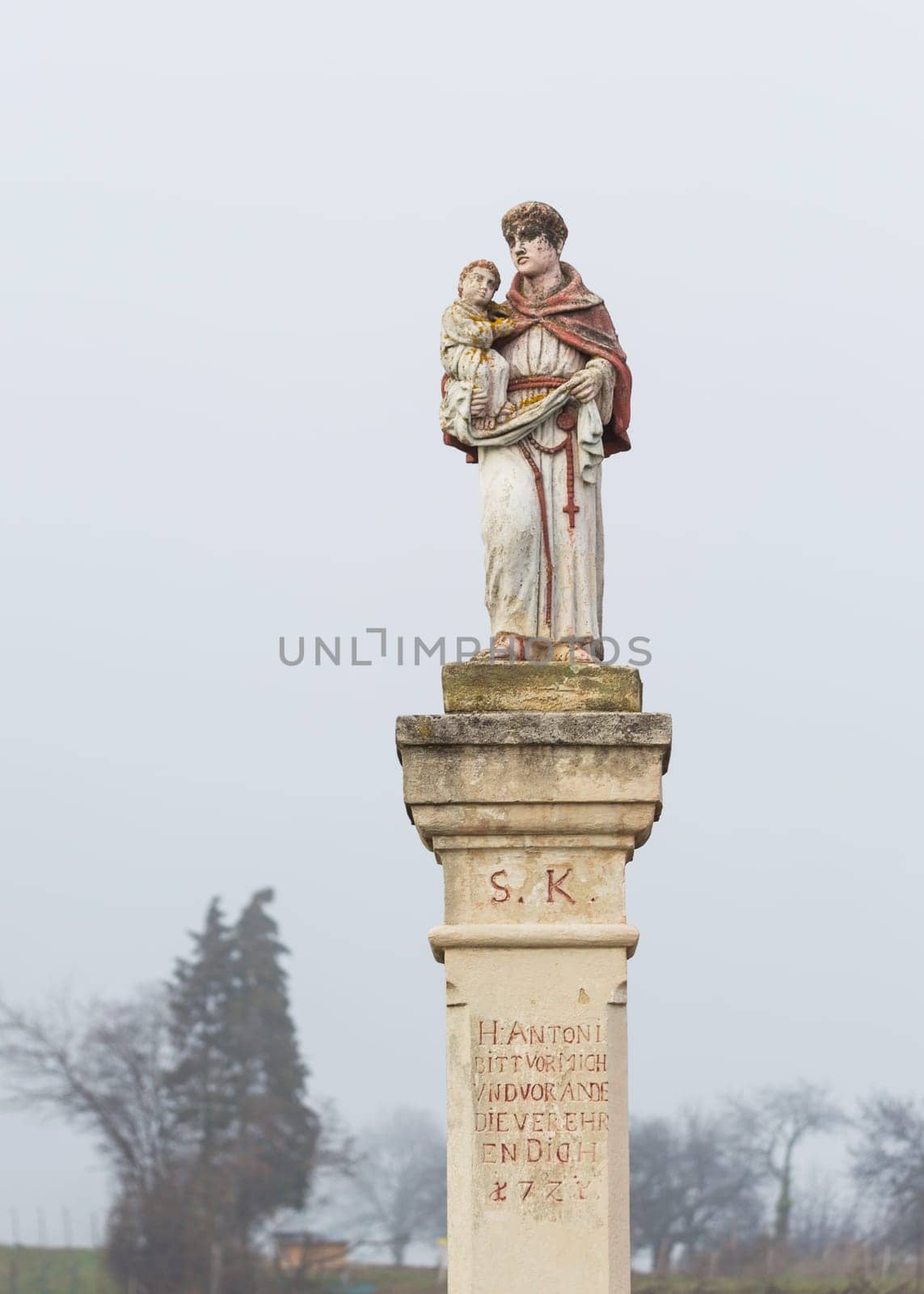 Statue with saint holding baby jesus on a waycross in Burgenland
