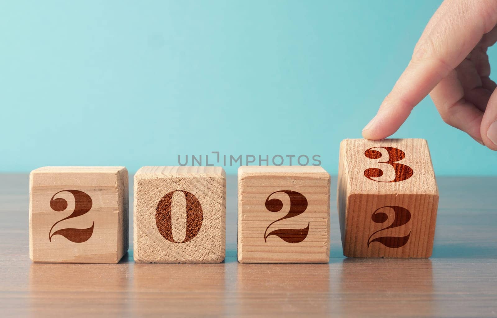 Flipping wooden cubes with the Year number 2022 and 2023, New Year concept, seasonal Christmas time