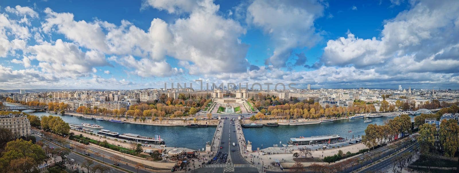 Scenery view from the Eiffel tower height to the Paris cityscape, France. Seine river, Trocadero area and La Defense metropolitan district seen on the horizon