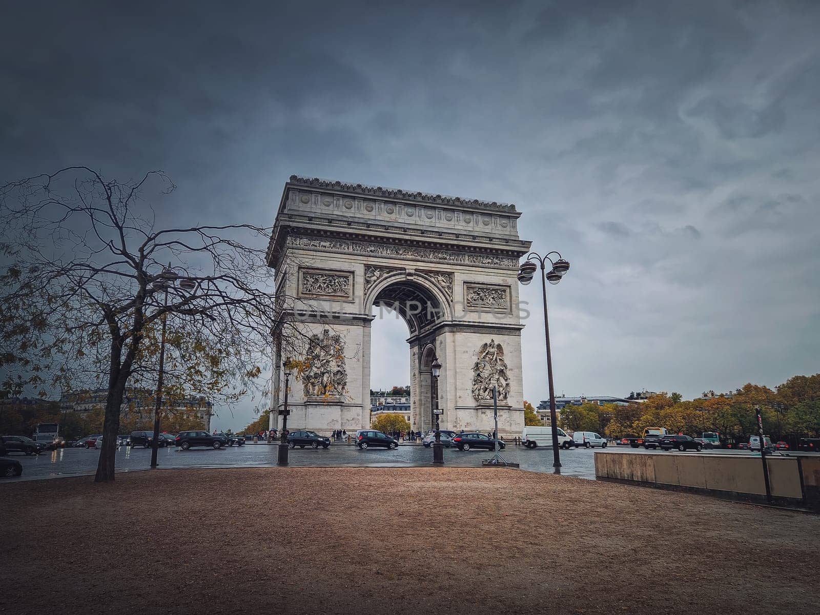 Arc de triomphe in Paris, France. Rainy autumn day with a romantic view to the triumphal arch landmark from avenue
