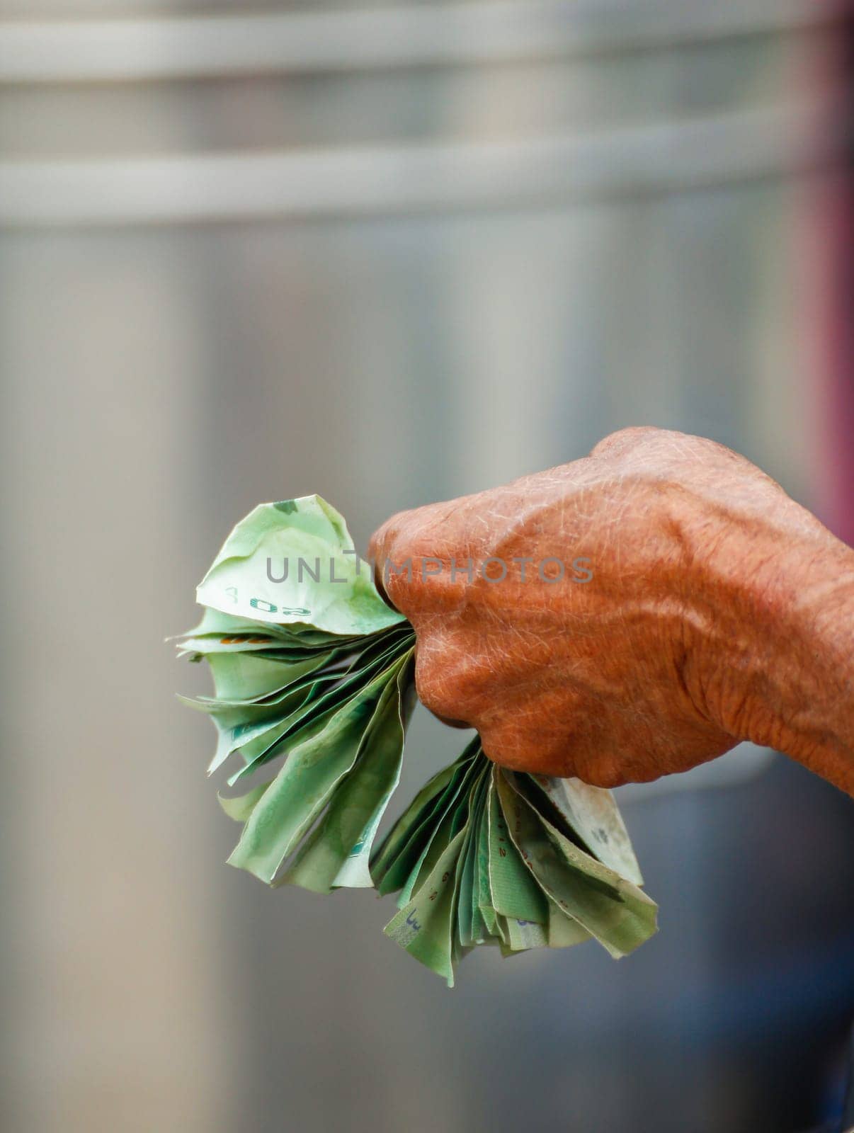 Close up of an elderly woman's hands holding money