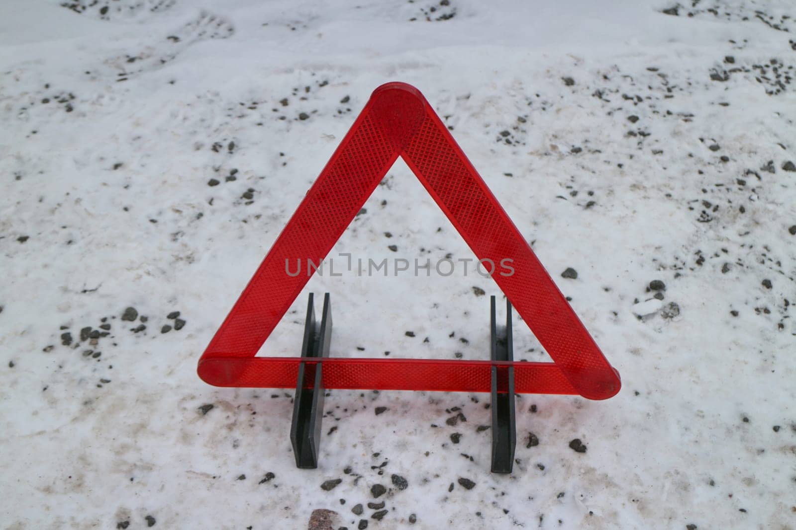red warning triangle on winter road, danger concept