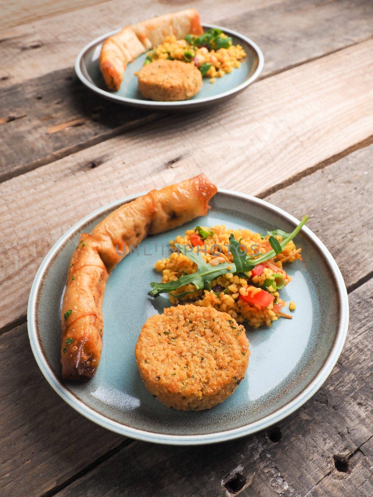 Tasty Falafel with spicy bulgur and a vegetarian dough roll on a ceramic plate, traditional heatlhy food