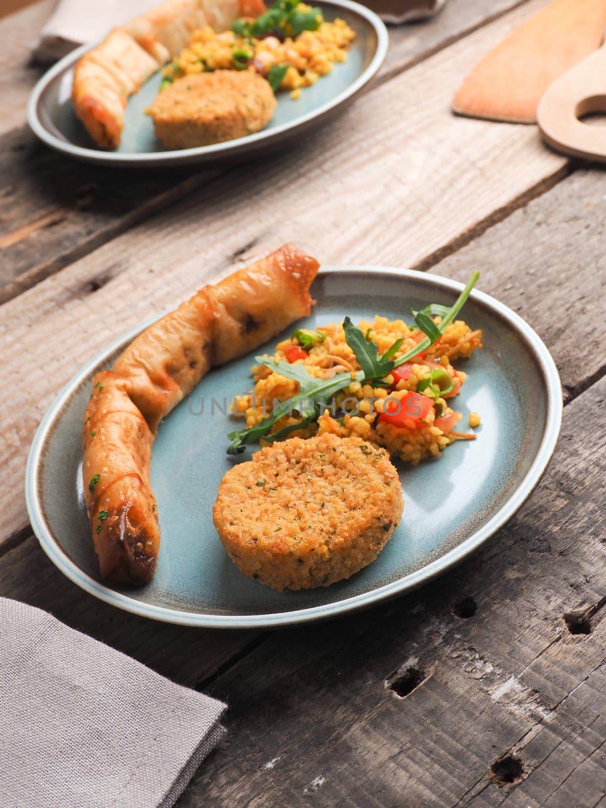 Tasty Falafel with spicy bulgur and a vegetarian dough roll on a ceramic plate, traditional heatlhy food