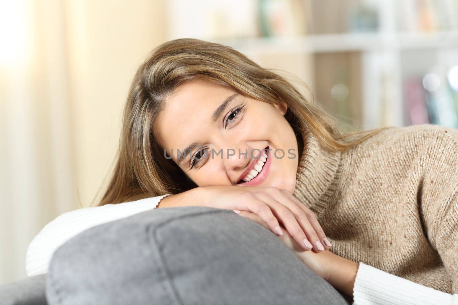 Portrait of a happy woman at home looks at you