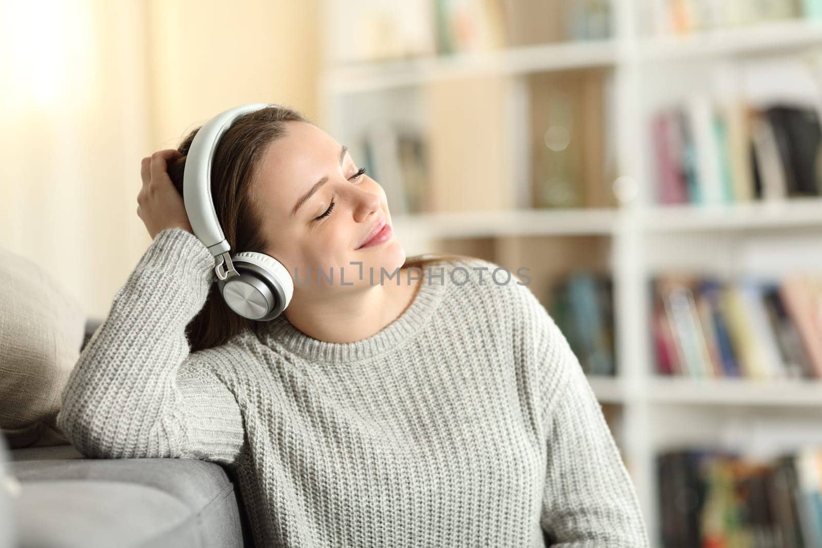 Happy teen wearing headphones listening to music at home