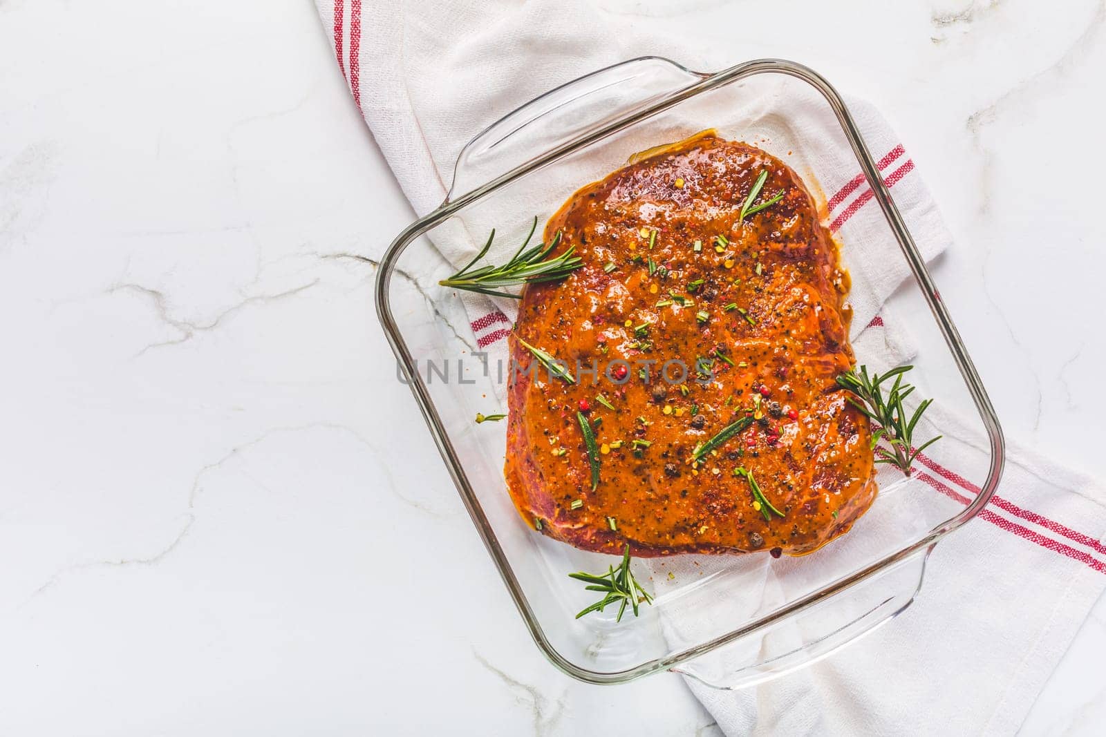 Classic marinated beef flank steak in bowl on white kitchen table