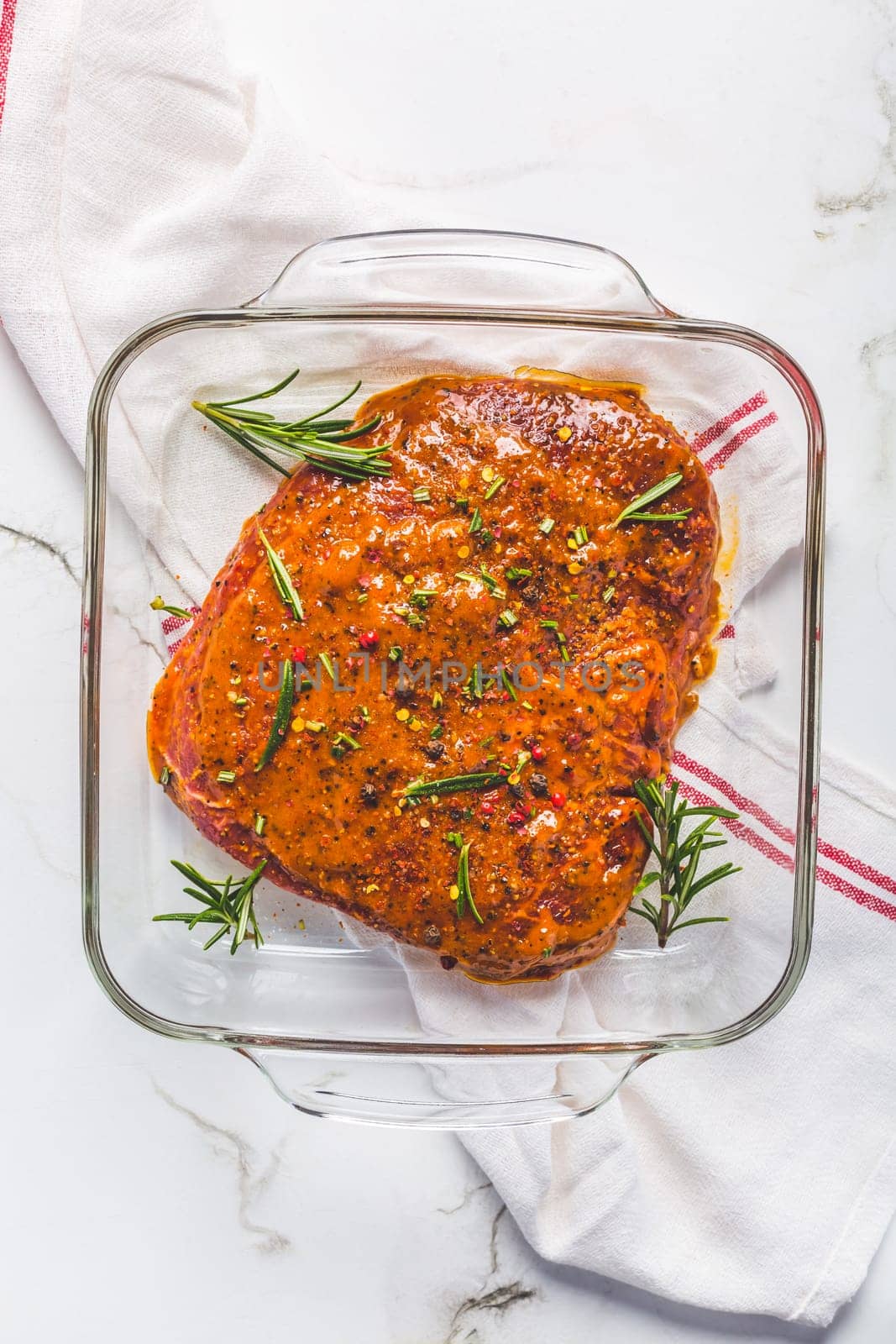 Classic marinated beef flank steak in bowl on white kitchen table