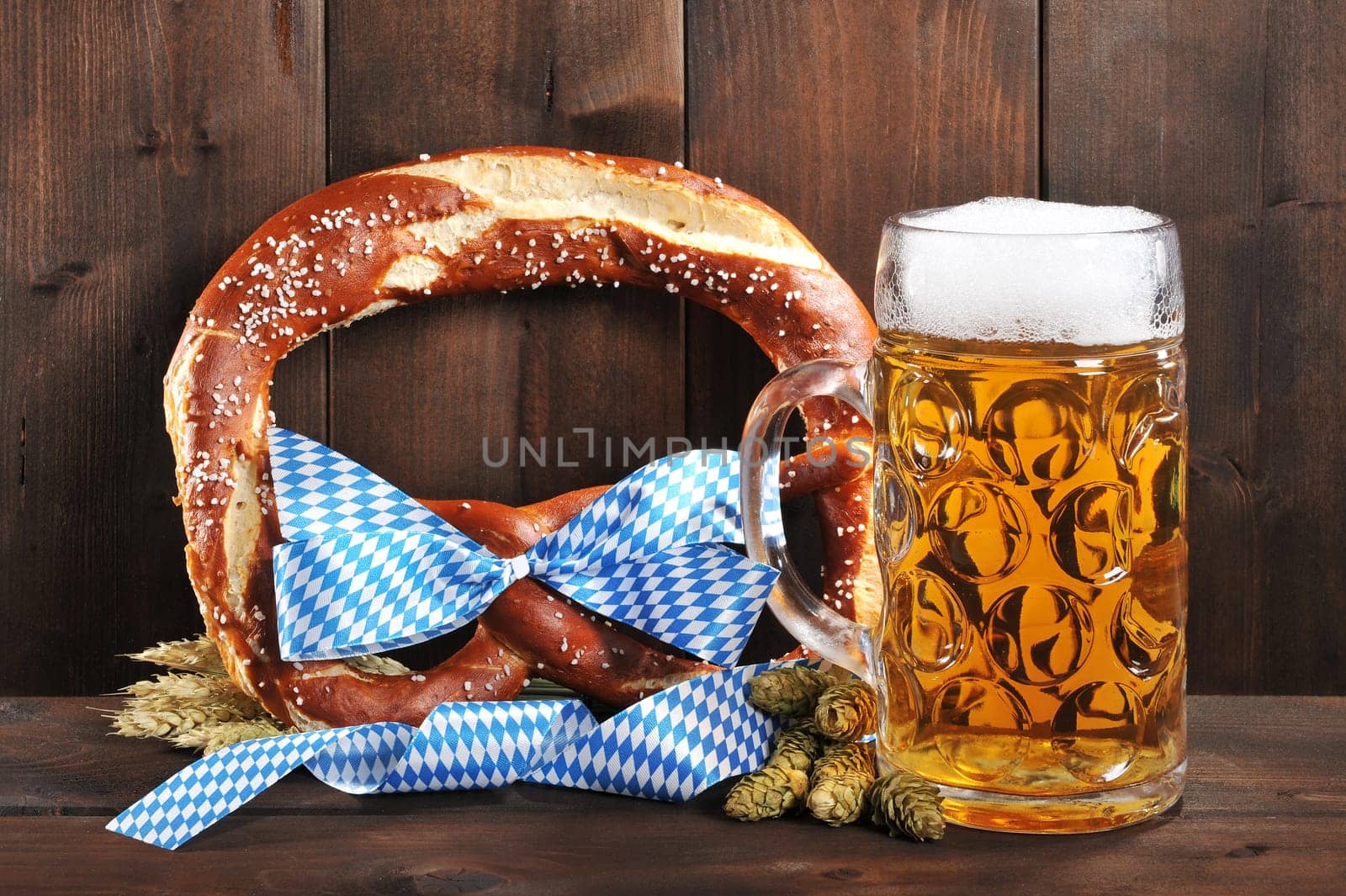 original Bavarian XXL Oktoberfestbreze with beer jug,hops and wheat in front of old holtbrettern