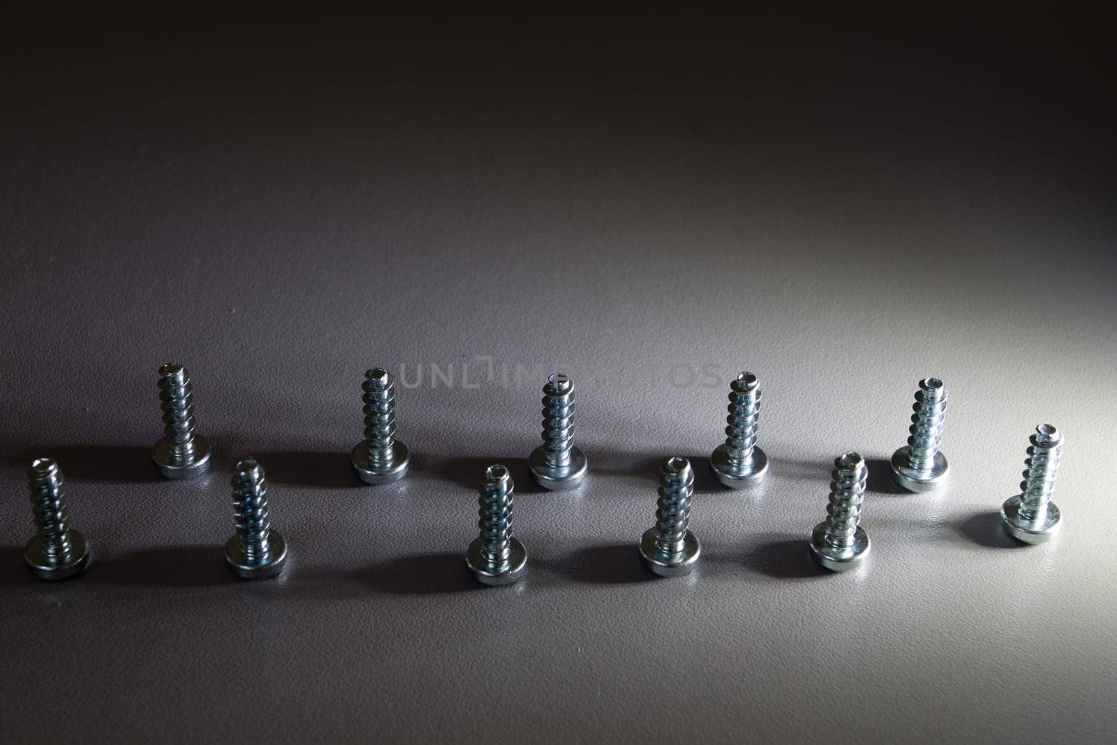 Screws standing illuminated by lateral light